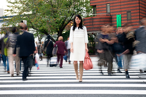 Beautiful Japanese woman waiting in the middle of a pedestrian crossing