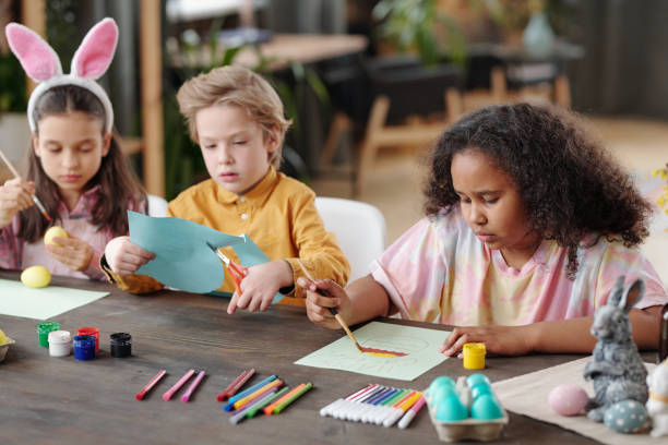 istock Three cute little friendly children of various ethnicities preparing for Easter 1305955417
