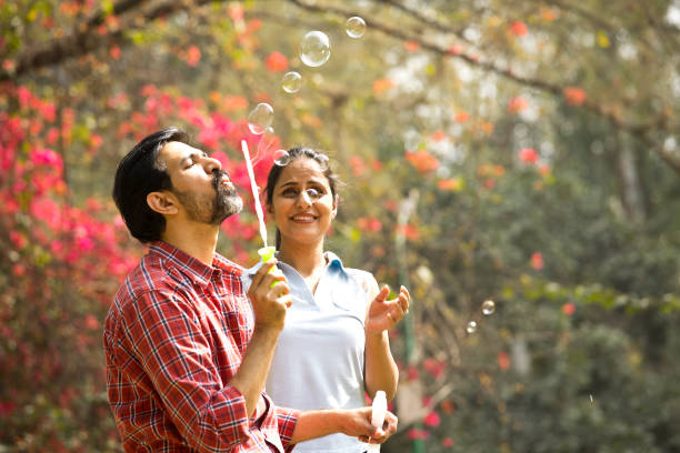 istock Couple blowing bubbles at park 1305956174