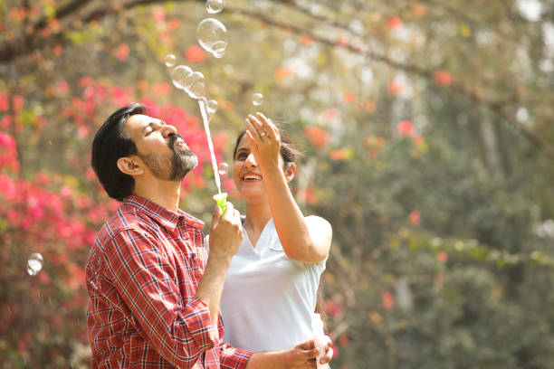 istock Couple blowing bubbles at park 1305956266