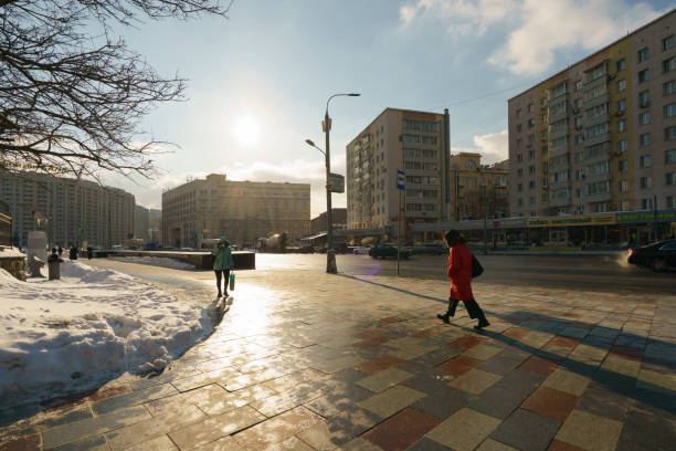 Moscow, Russia - February 17, 2021:  People at the cold winter sunny day at the street during coronavirus pandemic after snowy blizzard. Lifestyle concept.