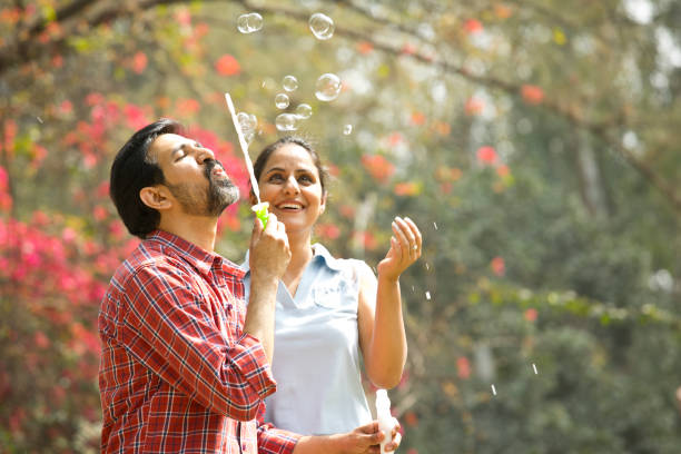istock Couple blowing bubbles at park 1305956342