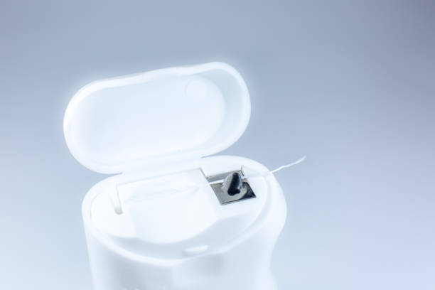 istock Dental floss on a gray background. Opened box, close up photo. 1305958352