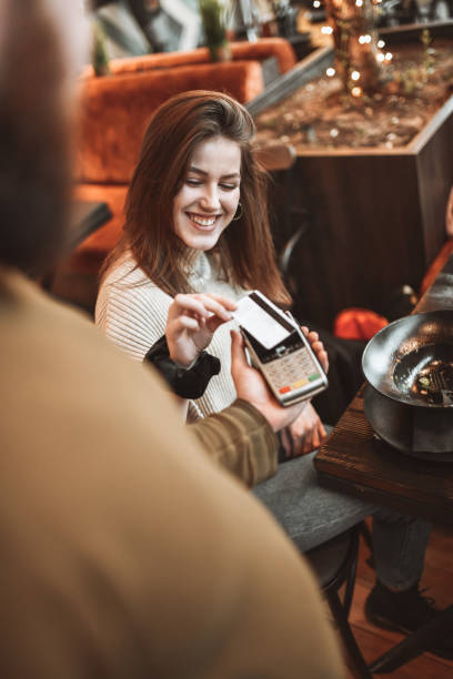 istock Cute Female Using Modern Methods Of Payment In Restaurant 1305959165