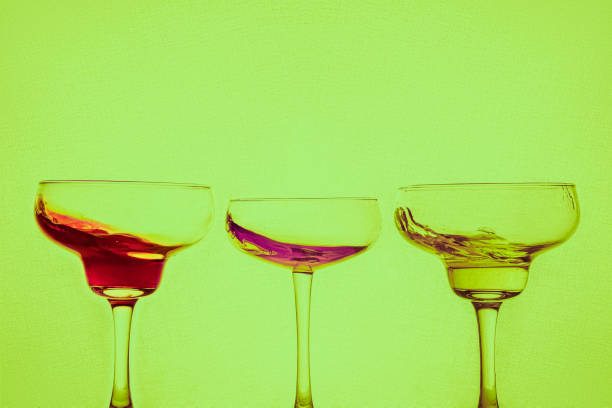 istock Colored cocktails with splash on neon green background. 1305960210