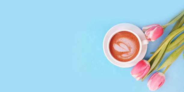 istock cup of coffee. tulip flower on colored background 1305963492