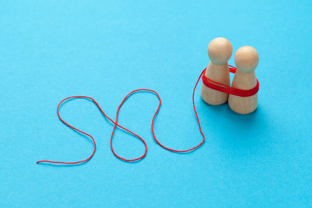 istock Strong affection of people. The pair of figures is connected by a red thread as a close relationship. Family consultation 1305965085
