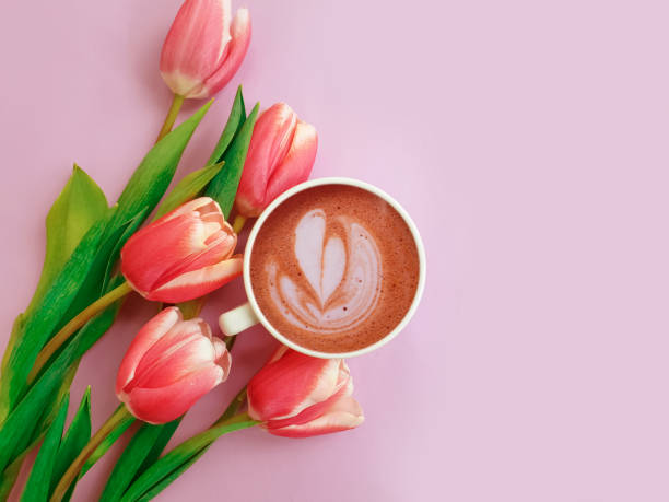 istock cup of coffee. tulip flower on colored background 1305966670