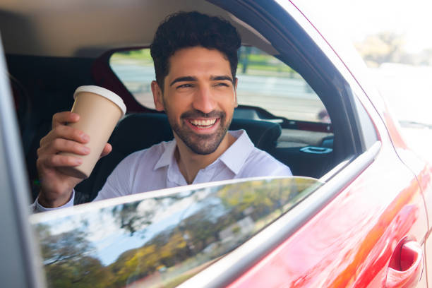 istock Businessman drinking coffee in car. 1305969545