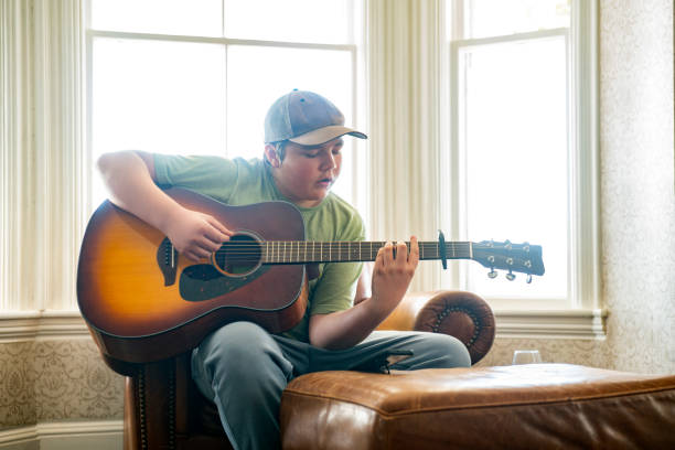 istock A child learning to play guitar at home using a smartphone 1305970124