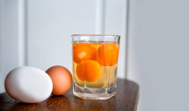 istock Egg Yolk and White in the Glass on white Kitchen background 1305971184