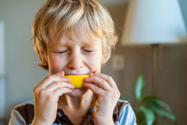 Lemon eating Boy eating sour lemon sour taste stock pictures, royalty-free photos & images