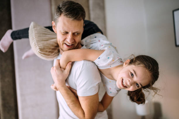 istock Father having fun with a daughter in a bedroom 1305974804