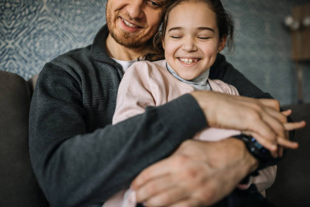 istock Father and daughter hugging on a sofa 1305975688