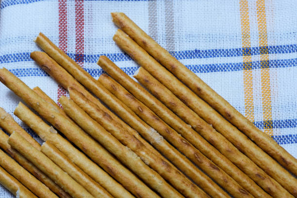 Sweet appetizer baked pastry sticks with salt crystals on a napkin close-up