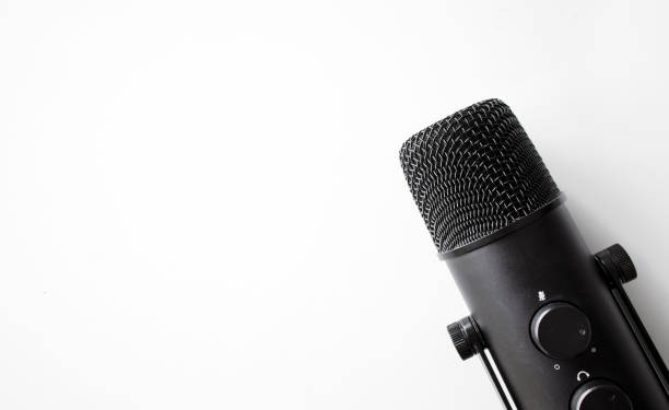 istock microphone on white table with soft-focus and over light in the background. space for text. 1305978135