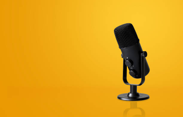 istock microphone on yellow background with soft-focus and over light in the background. space for text. 1305978183