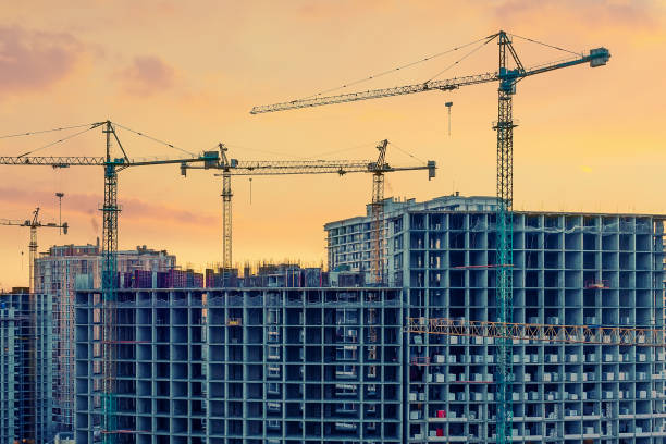 istock Construction site, cranes and multi-storey unfinished buildings at sunrise or sunset 1305979094