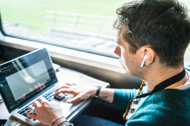 istock Businessman working on train with laptop 1305980476