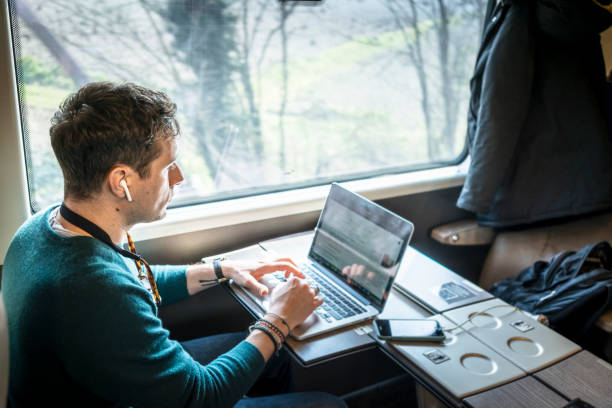 istock Businessman working on train with laptop 1305980478