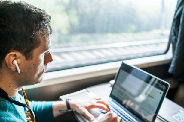 istock Businessman working on train with laptop 1305980506