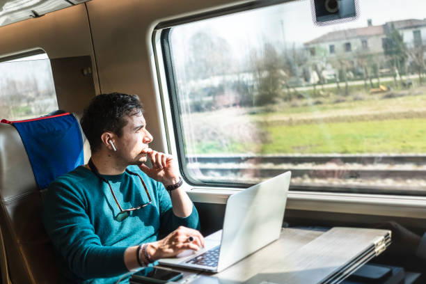 istock Businessman working on train with laptop 1305980525
