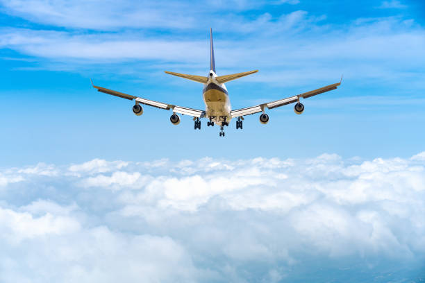 istock rear image commercial passenger aircraft or cargo transportation airplane flying over white fluffy cloud with blue sky and spread the wheel prepare landing to airport 1305982761