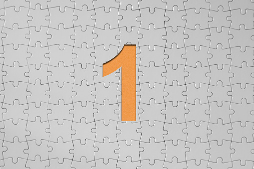 Number one - Jigsaw Puzzle Pieces Forming A Cut Out Orange Number One, Also there is blank areas for your text.