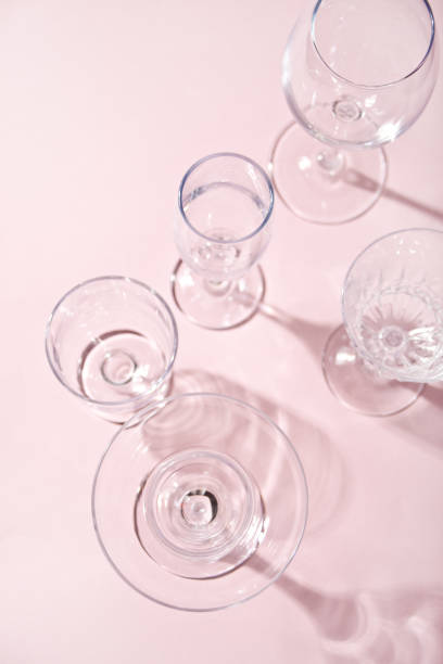 istock Empty different glasses on a light pink background. Top view. 1305985858