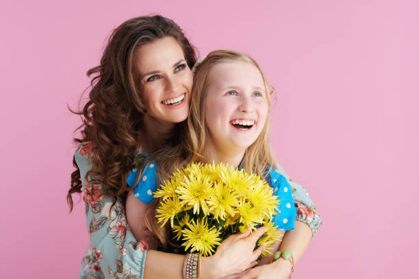 istock smiling stylish mother and child hugging on pink 1305987356