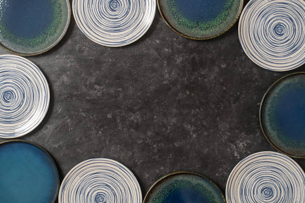 istock Many color empty ceramic plate on black background, with copy space for your text 1305987572