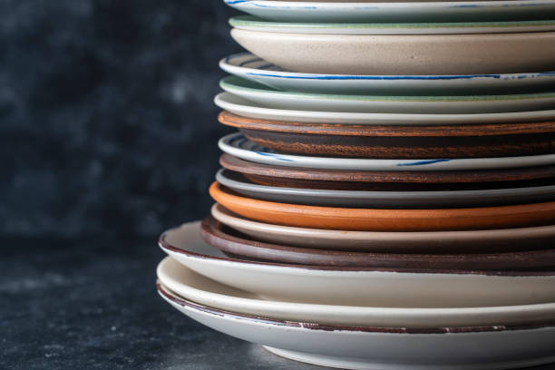 istock Many empty plate on black background, close up 1305987605