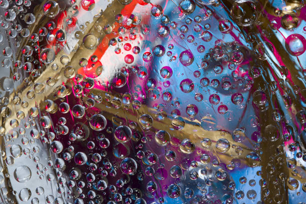 istock Multicolored spheres are located against a violet-blue background with dry leaves located on it. 1305987619