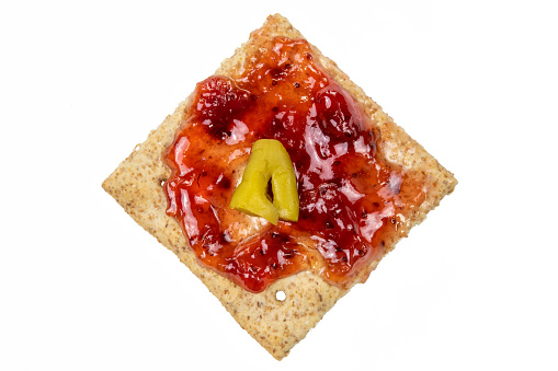 Cracker with strawberry jam and spicy-hot pickle