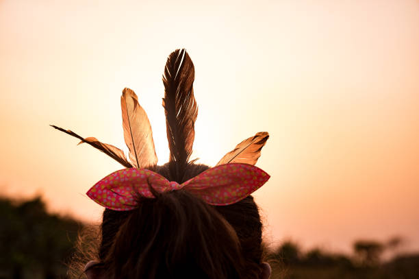 la petite fille porte des plumes sauvages plus grandes d’oiseau coucal sur ses cheveux sur la terre de blé au bord de la rivière de campagne jalangi dans l’après-midi. - coupe en dégradé photos et images de collection