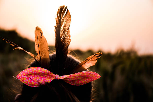 la petite fille porte des plumes sauvages plus grandes d’oiseau coucal sur ses cheveux sur la terre de blé au bord de la rivière de campagne jalangi dans l’après-midi. - coupe en dégradé photos et images de collection