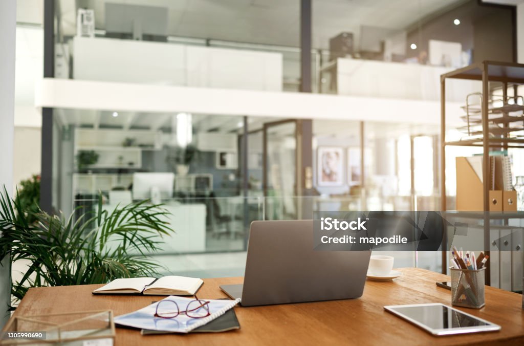 An organised workspace leads to more productivity Shot of a laptop on a table in an office Office Stock Photo