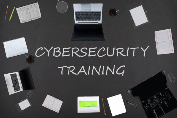 istock Cybersecurity training concept. Top layout of drawings of laptops, notepads, coffee, different business stuff on black background. 1305990986