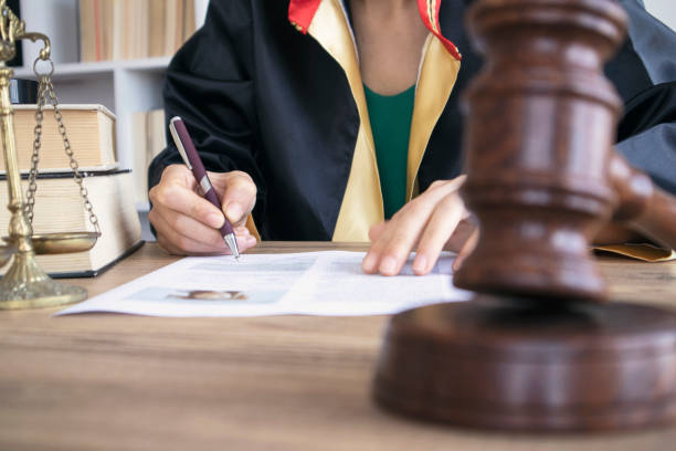 Woman lawyer working with contract papers and wooden gavel on tabel in courtroom. justice and law ,attorney, court judge, concept. stock photo