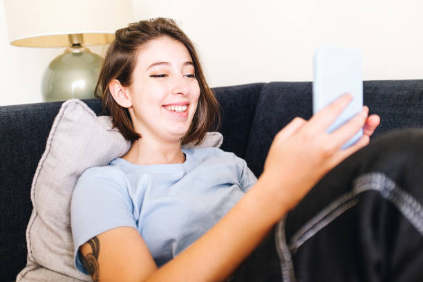 istock Smiling girl typing on her cellphone 1305992011