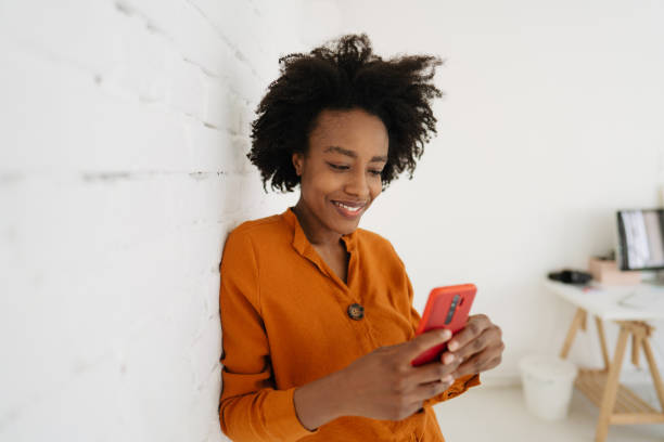 istock Young smiling woman using her phone 1305992423