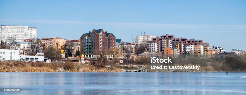 City landscape. Panoramic shot from the frozen river on the banks of which new multi-storey buildings have been erected Vinnytsia Stock Photo