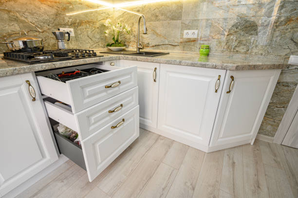 istock Drawers pulled out at modern classic white kitchen furniture 1305998776