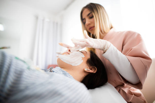 mujeres en tratamiento de belleza en clínica de cosmetología - head massage massaging facial massage beautician fotografías e imágenes de stock