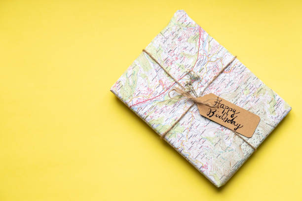 Birthday gift in nice vintage wrapping on yellow backgroundConceptual retro style decoration