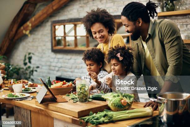 Happy African American Family Preparing Healthy Food In The Kitchen Stock Photo - Download Image Now