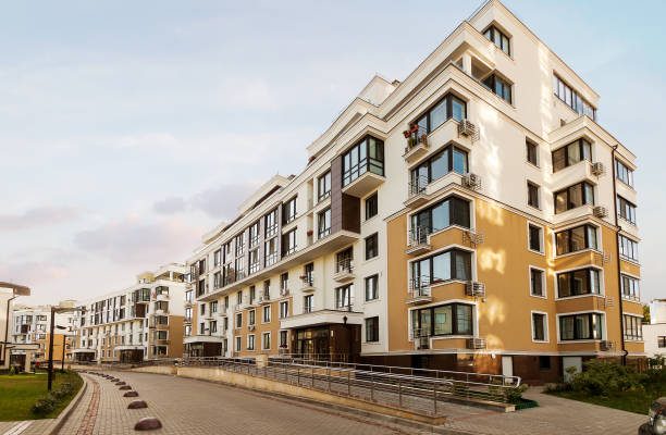 case basse a uso misto urbano multi-famiglia zona residenziale sviluppo sfondo cielo soleggiato blu - apartment foto e immagini stock