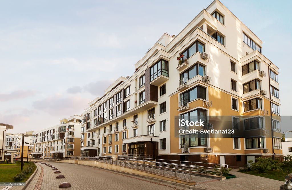 Low-rise houses mixed-use urban multi-family residential district area development blue sunny sky background Real estate low rise construction building exterior in new residential area for sale blue sky sunny background. Urban development concept image Apartment Stock Photo
