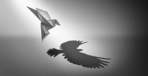 Vision and ambition as a business symbol for leadership power and success metaphor for growth as an origami paper bird casting a shadow of powerful real wings in a 3D illustration style.