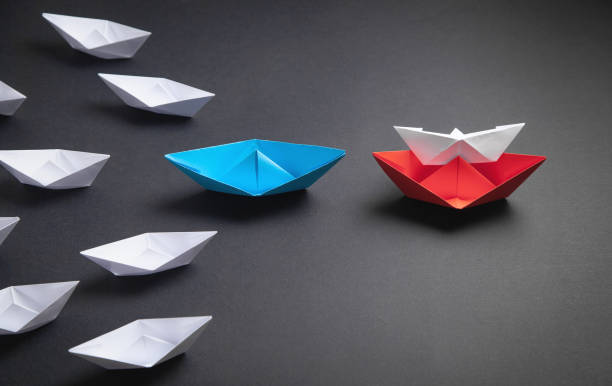 istock Red, blue and white paper boat. Leadership concept 1306007507